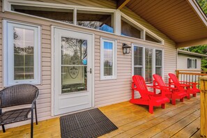 Enjoy your morning coffee or evening drink on the front deck, complete with bright red Adirondack chairs, perfect for soaking in the peaceful surroundings.