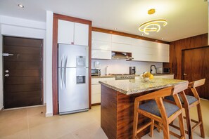Modern Kitchen & Dining Area – Fully equipped kitchen with sleek appliances and a granite island, perfect for preparing meals at home.