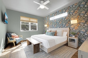 Upstairs primary suite with king bed and portable crib in closet