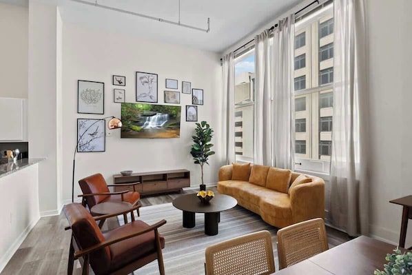 Welcome to this stylish, open-concept loft featuring modern design with high ceilings and large windows for plenty of natural light. Enjoy the cozy living space with a dartboard and shuffleboard, perfect for a relaxing night in