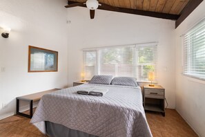 Primary bedroom with ceiling fan and ensuite bathroom.