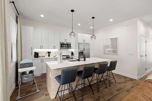 Our fully stocked kitchen features a large island with high seating and a convenient high chair for the little ones.