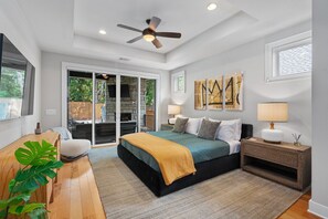 The master suite features a king-sized bed with luxury linens and large windows overlooking the pool area, creating a tranquil atmosphere for relaxation.