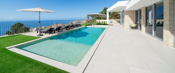The Beautiful Villa Adagio By Ourmadeira Showing The Large Picture Windows Large Pool Deck And Swimming Pool And The Breathtaking Seaview