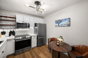 Fully stocked kitchen and dining area with modern appliances, wine glasses, coffee machine, and all you need for you stay!