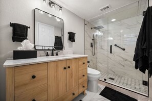 Private en-suite bathroom, freshly updated with walk in glass rain shower, and vanity area.