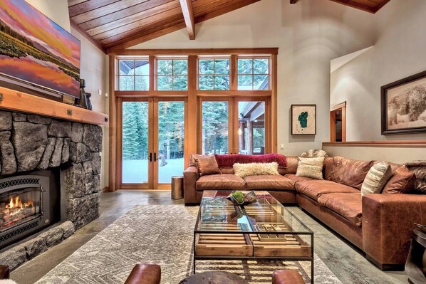 Our cozy "great room" with vaulted ceilings, a gas fireplace, leather sectional and french doors that open to the patio/hot tub.