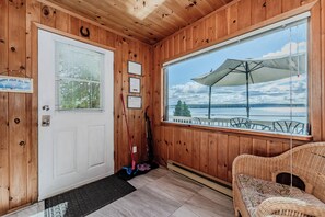Step into the cottage and immediately take in the picturesque view of the bay through the large window, creating a warm and inviting atmosphere.