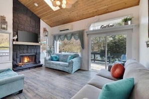 A living room designed for connection and relaxation. The fireplace is the heart of the home.