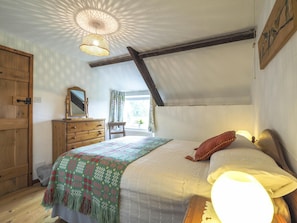 Double bed with bedside tables and table lamps. Chest of drawers with mirror. Wooden wall art