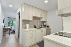 A well appointed full kitchen with bright cabinetry and modern appliances