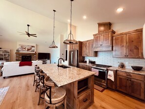 Full kitchen with refrigerator, microwave, dishwasher, and stove w/ air fryer.