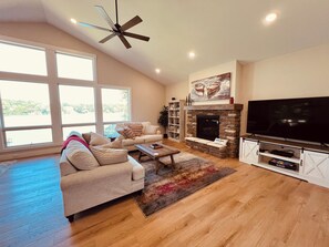 Living room with gas fireplace, smart tv, and amazing lake view!