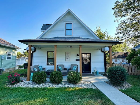 Front of the home. With inviting front porch and comfy furniture.