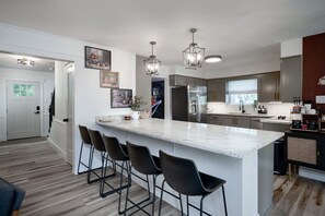 Fully stocked kitchen with a large bar opening to living area