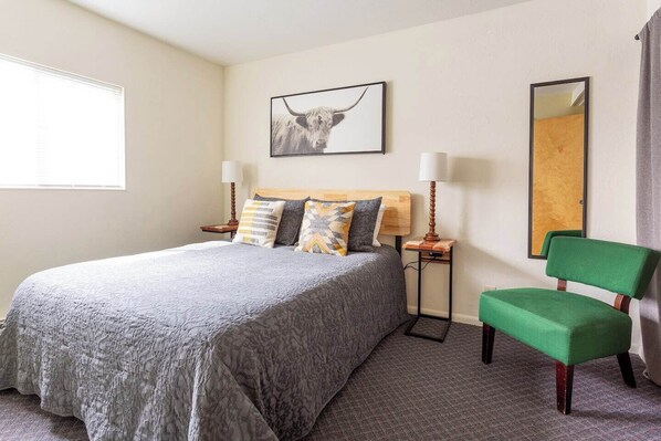 Variable lighting, pillows for propping, and crisp, clean bed linens envelop a comfortable queen mattress for restful sleep.
