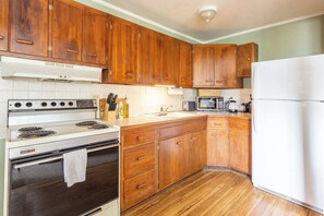 The kitchen is compact but adequately stocked with all the essential tools needed for prepping simple meals - stainless pots and pans, mixing bowls, baking dishes, utensils etc.- plus coffee, tea, and a selection of pantry items. 