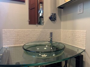 Each of the 3 bathrooms has a unique glass sink.