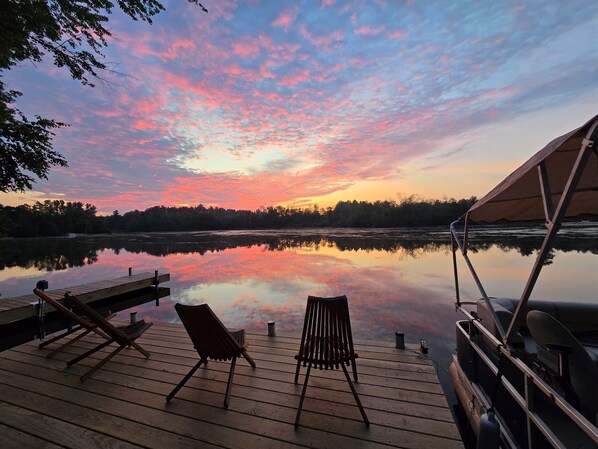 Nestled in nature, this charming lakeside cabin boasts a spacious deck with stunning views! Perfect for a peaceful retreat, it offers easy lake access and cozy outdoor seating.