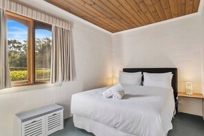 The very comfortable first bedroom includes a queen size bed, nightstands, and a bench for getting ready.