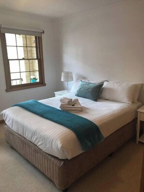 The first bedroom overlooking the balcony features a king-sized bed along with an infant cot. 