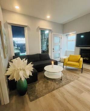 living room with queen pull out and gas fireplace below smart tv 