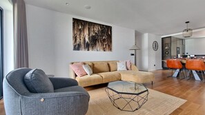 Inviting living room featuring a sleek armchair and a stunning huge glass wall paint that floods the space with natural light, complemented by modern décor that enhances the overall aesthetic. #modern #warm #invitingdecor