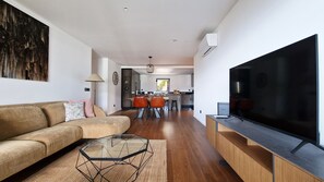 Modern open-plan living room with a large smart TV, fast Wi-Fi, and a comfortable sofa, featuring stylish décor for relaxation, #luxurious #apartment #funchal