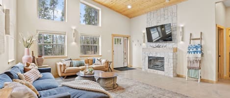 Leather + velvet couches, wall sconces, smart TV, electric fireplace, ottomans