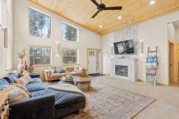 Leather + velvet couches, wall sconces, smart TV, electric fireplace, ottomans