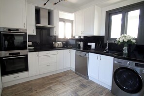 Fully equipped kitchen with modern appliances and a washing machine