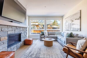 Spacious living room with cozy gas fireplace and huge Smart TV. Perfect for movie night on a chilly winter's eve.