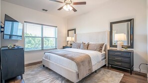 Unwind in the luxurious master bedroom, featuring a plush king bed and elegant decor designed for ultimate comfort and relaxation.