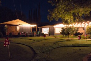 Outdoor Patio with String Lights and Projector Screen: "Transform your evenings into a cinematic experience with our outdoor patio, featuring ambient string lights and a large projector screen for unforgettable movie nights."