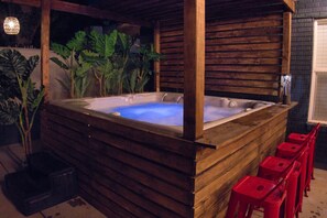 Hot Tub with Night Lighting: "Relax and rejuvenate in our inviting hot tub, surrounded by lush greenery and ambient lighting—a true sanctuary for evening relaxation."