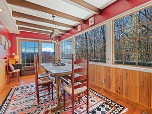 Dining room with large windows, rustic charm, and panoramic mountain views.