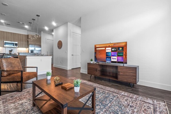 Bright and airy living room with plush seating, a large TV, and tasteful decor, creating the perfect space for relaxation and entertainment.