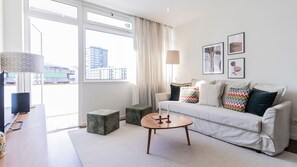 Kick back and relax in this bright and welcoming living room, featuring a plush sofa adorned with decorative pillow. #airbnb #modern