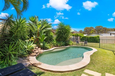 A tropical garden surrounds the pool, alive with the sound of birds.