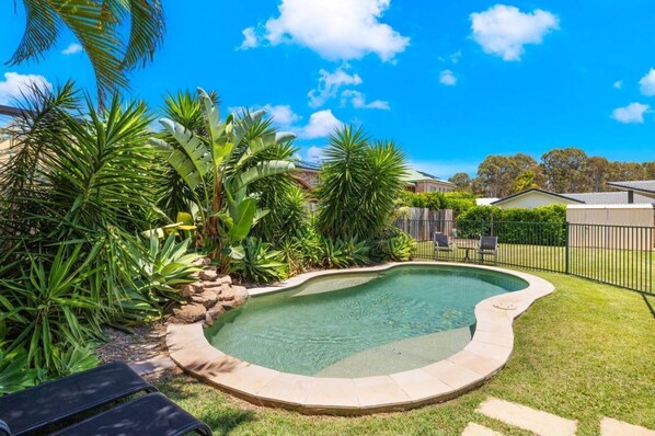 A tropical garden surrounds the pool, alive with the sound of birds.