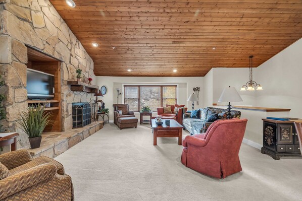 Living Room: Couch, 3 chairs, wood burning fireplace, 40” TV w/cable