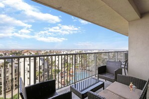 A cozy balcony furnished with outdoor seating, ideal for relaxing and taking in the expansive views of the city.