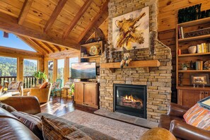Living room with gas fireplace, TV, and comfy seating.