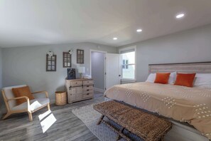 This light and bright bedroom offers everything you need for a restful night's sleep, featuring a comfortable queen-sized bed and charming décor.
