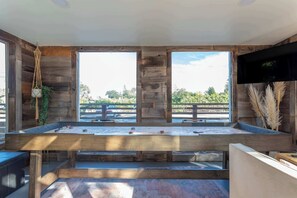 Welcome to the ultimate game room—complete with a cozy couch, TV, Pac-Man arcade game, shuffleboard, and those unbeatable vineyard views.