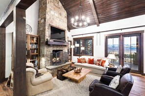 Luxurious Living Room – Plush seating, a grand fireplace, and warm tones create a sophisticated yet cozy escape.