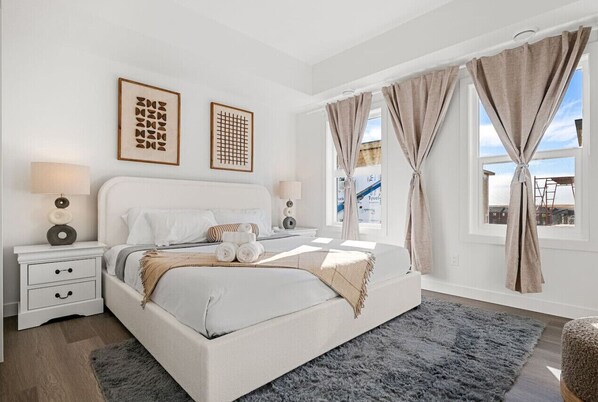 Indulge in a luxurious night’s sleep in Bedroom #1, featuring a king-size bed with ultra-soft, luxurious linens, blackout curtains for restful sleep, and a stylish mirror to complete the room’s modern look.