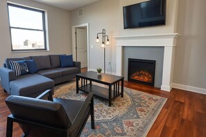 Cozy Downtown Living – Modern Lounge Cozy Living Room – Fireplace, Smart TV & Stylish Seating for Relaxationwith Fireplace & Smart TV