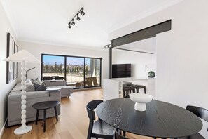 L-shaped living space with 65-inch smart TV and separate dining
