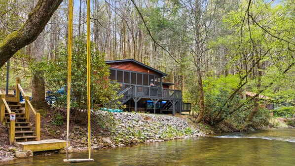Experience the serene melodies of the nearby creek as children playfully swing above its gentle currents.